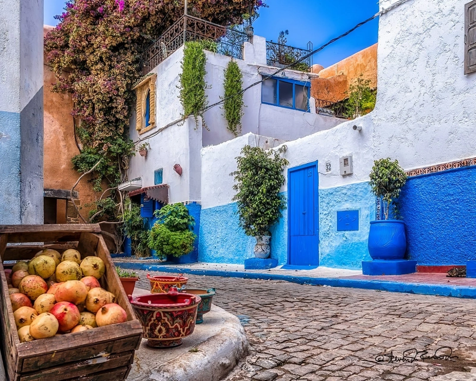 Ruelle bleue et blanche avec des grenades à Rabat